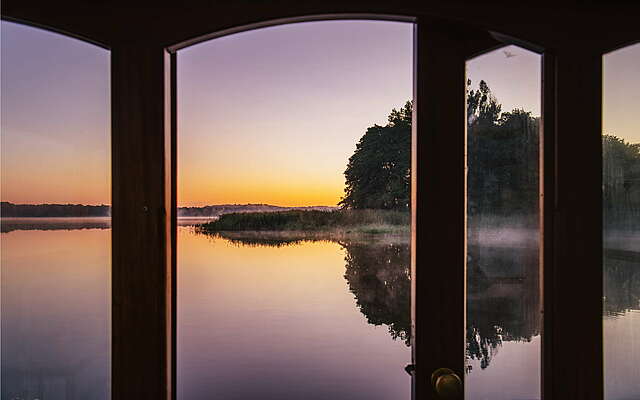 Fensterblick mit Sonnenuntergang