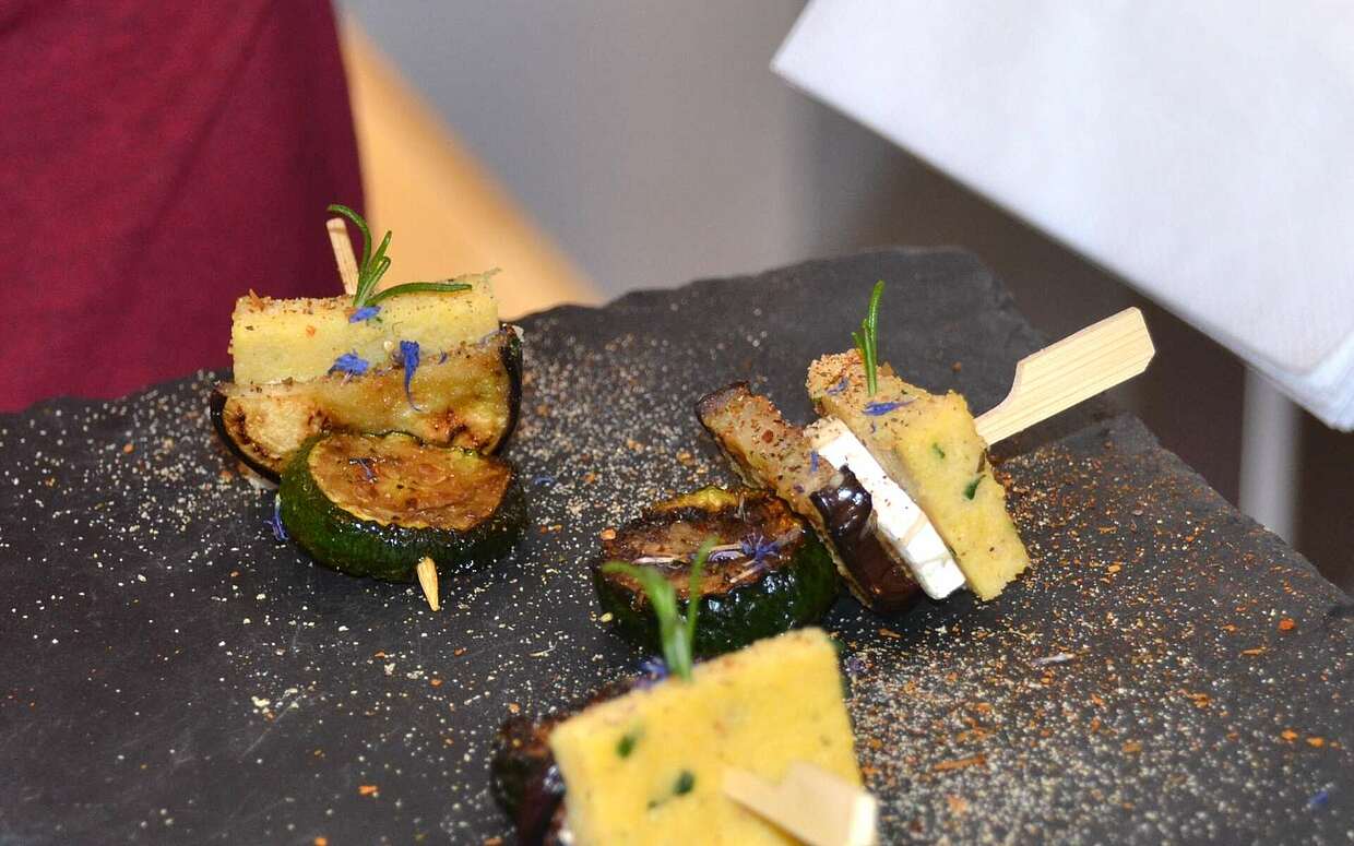 Leckerer Happen: Den Polenta-Zucchini-Ziegenkäse-Spieß gibt es gleich an der ersten Station der Tour.