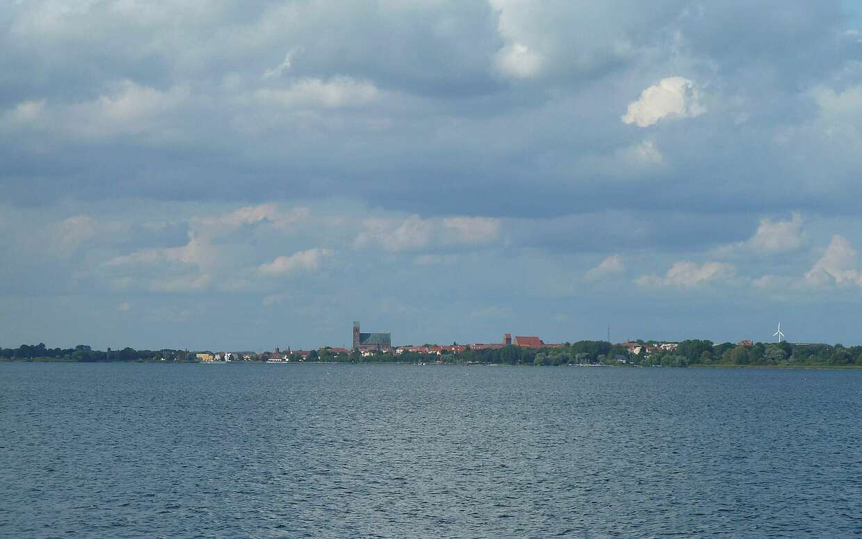 Die Silhoutte von Prenzlau vom Unteruckersee aus gesehen: Das höchste Gebäude ist der Turm der Marienkirche, rechts daneben das ehemalige Dominikanerkloster.