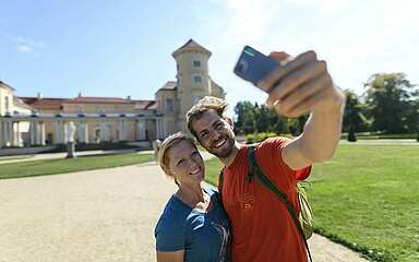 Besucher im Schlossgarten Rheinsberg mit Handy