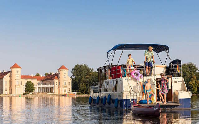 Kormoran vor Schloss Rheinsberg mit Familie am Heck