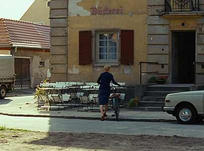 Schauspielerin Nina Hoss in der Rolle der Barbara schiebt ihr Fahrrad zur Bäckerei.