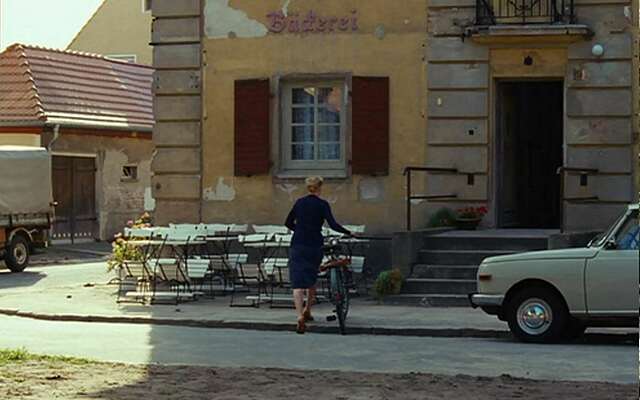 Schauspielerin Nina Hoss in der Rolle der Barbara schiebt ihr Fahrrad zur Bäckerei.