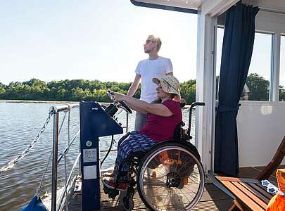 Rollstuhlfahrerin auf Hausboot
