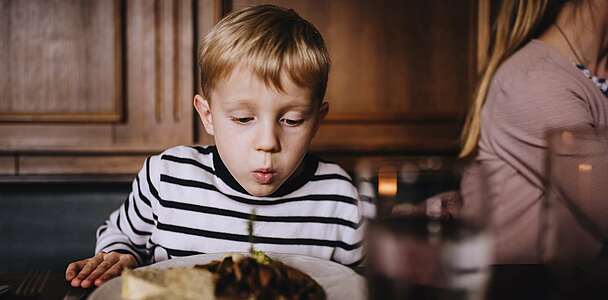 Junge pustet Essen kalt