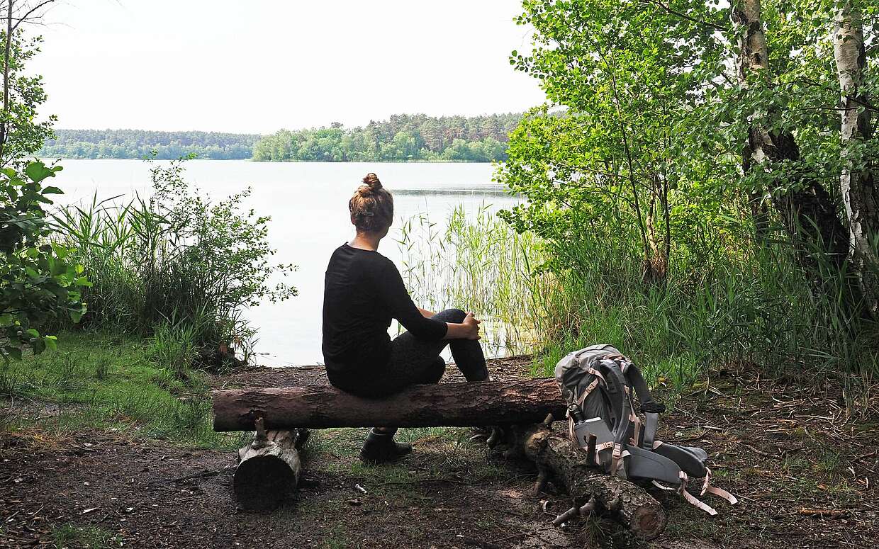 Wanderin auf Bank am Stechlinsee