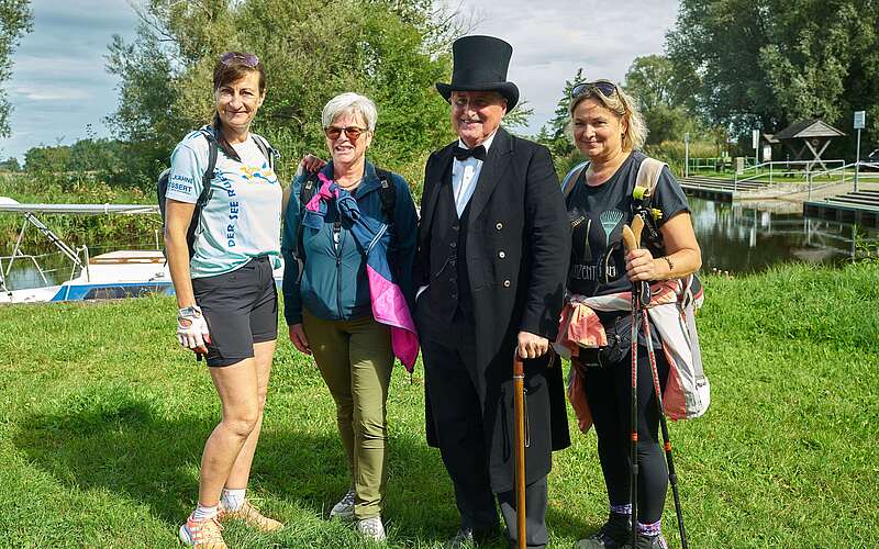 <p>Drei Frauen in sportlicher Kleidung posieren mit einem als Theodor Fontane verkleideten Mann für die Kamera.</p>