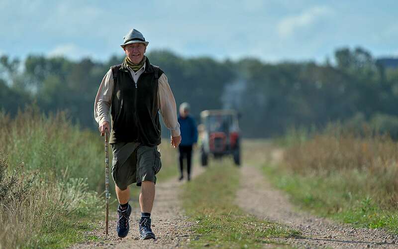 



    
        
                Wanderer in bayrischer Tracht auf einem Feld,
            
        
                Foto: Tourismusverband Ruppiner Seenland e.V./Jannika Olesch
            
    
