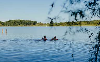 Kinder schwimmen im See