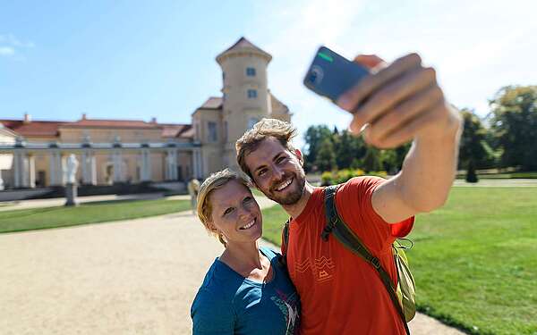 Besucher im Schlossgarten Rheinsberg mit Handy