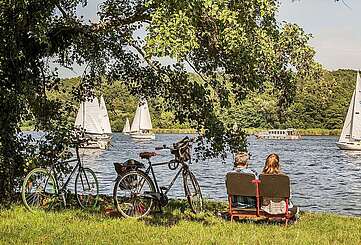 Radfahrer machen Pause und schauen aufs Wasser