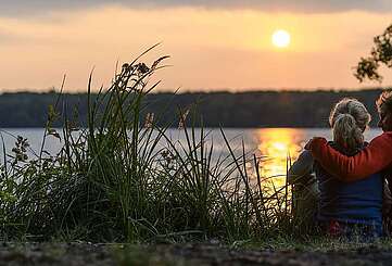 Paar genießt den Sonnenuntergang am Stechlinsee