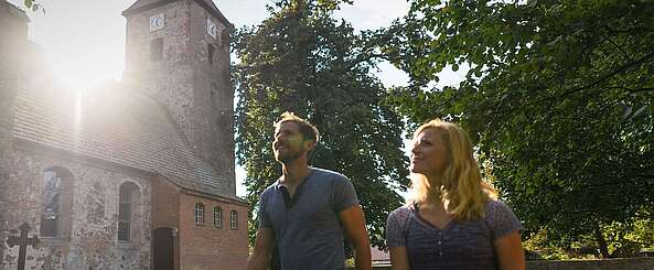 Besucher vor der alten Feldsteinkirche in Menz