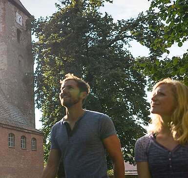 Besucher vor der alten Feldsteinkirche in Menz
