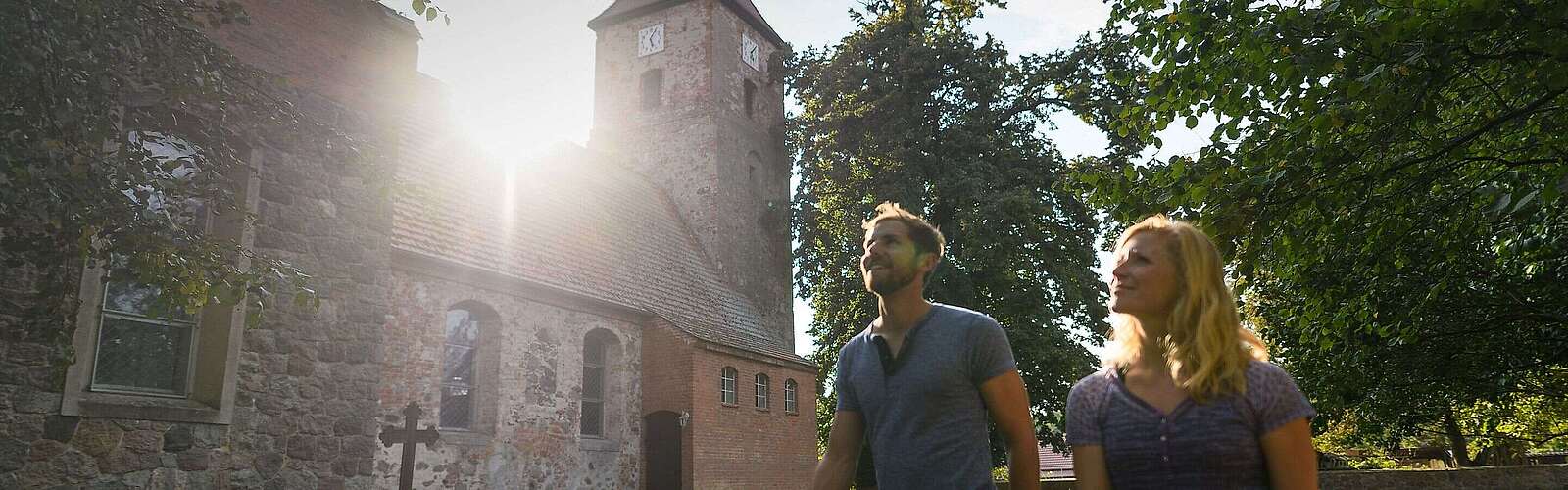 Besucher vor der alten Feldsteinkirche in Menz