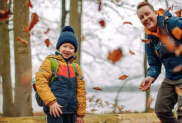 Junge spielt mit Laub