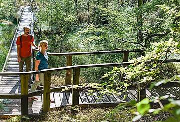 Besucher erkunden den Moorerlebnispfad bei Menz