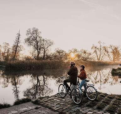 Radfahrer bei Sonnenaufgang im Spreewald