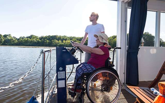 Rollstuhlfahrerin auf Hausboot