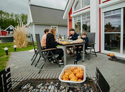 Familie am Tisch hinter dem Grill im Hafendorf Zerpenschleuse