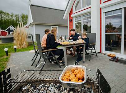 Familie am Tisch hinter dem Grill im Hafendorf Zerpenschleuse