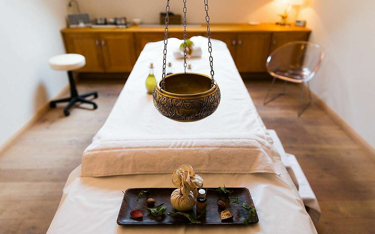 Massageliege mit Duftschale und Ölen
